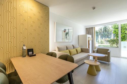 a living room with a couch and a table at Hotel Illa d'Or & Club Apts 4* Sup in Port de Pollensa