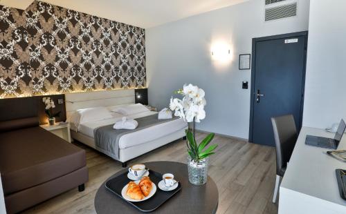 a room with a bed and a table with food on it at Hotel Molino Rosso in Imola