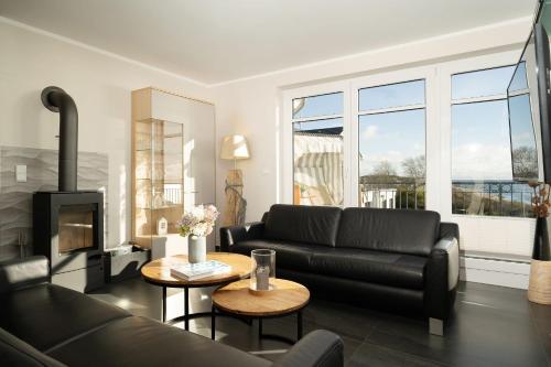 - un salon avec un canapé noir et une cheminée dans l'établissement Strandresidenz Vogelflug Penthouse 14, à Fehmarnsund