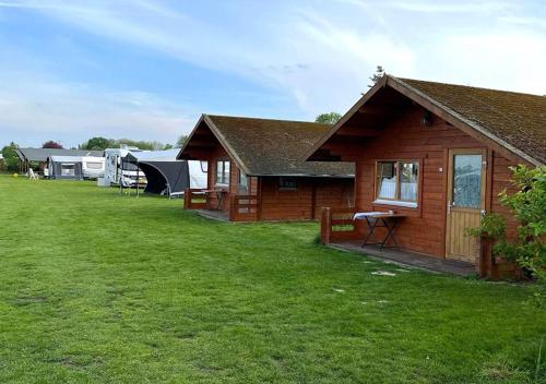 una baita di tronchi con un cortile di fronte di Mini Camping Drentse Monden a Nieuw-Weerdinge