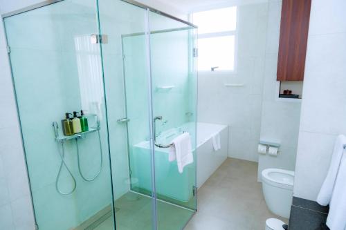 a bathroom with a glass shower and a toilet at Kigali Paramount Hotel in Kigali
