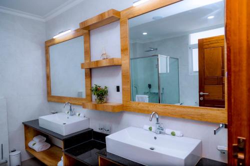 a bathroom with two sinks and a mirror at Kigali Paramount Hotel in Kigali