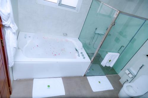 a bathroom with a shower and a tub and a toilet at Kigali Paramount Hotel in Kigali