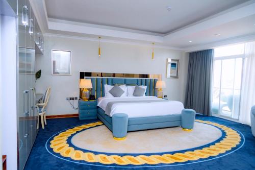 a bedroom with a large bed and a blue rug at Kigali Paramount Hotel in Kigali