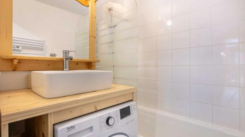 une salle de bain avec un lavabo et une machine à laver dans l'établissement Les Biches N81 - 3P6, à Saint-Sorlin-dʼArves