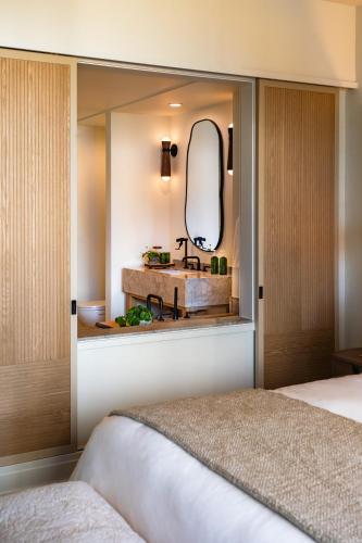 a bedroom with a mirror and a sink at 1 Hotel Seattle in Seattle
