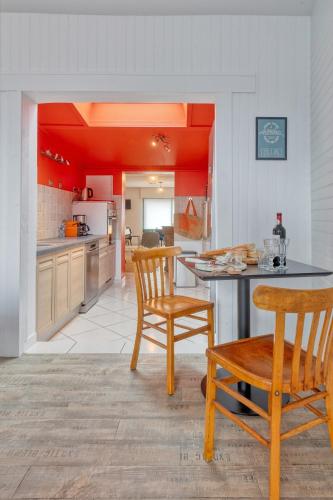 une cuisine avec une table, deux chaises et un comptoir dans l'établissement L'Escale Maison Bleue proche chantiers atlantique, à Saint-Nazaire