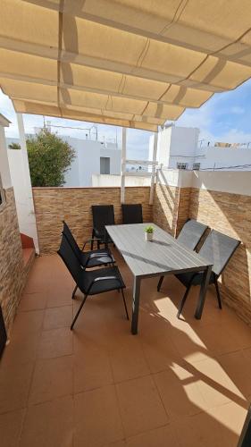 a patio with a table and chairs on a roof at Apartamento de lujo en Playa de Regla in Chipiona