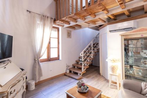 un salon avec un escalier et un canapé dans l'établissement Chambre romantique du Couvent, à La Celle-sous-Gouzon