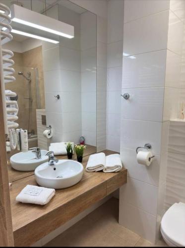 a white bathroom with two sinks and a shower at Zlatarooms 409 in Warsaw