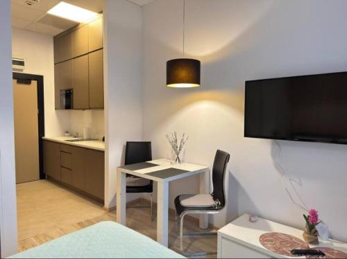 a room with a table and chairs and a kitchen at Zlatarooms 409 in Warsaw