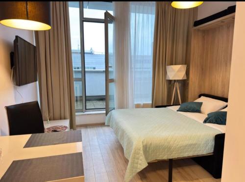 a bedroom with a bed and a large window at Zlatarooms 409 in Warsaw