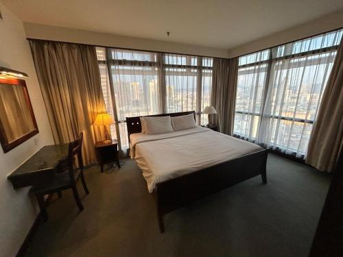 a bedroom with a large bed and large windows at KSM GLOBAL APARTMENT At TIMES SQUARE kl in Kuala Lumpur