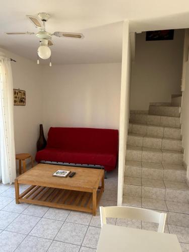 - un salon avec un canapé rouge et des escaliers dans l'établissement Maison 3 chambres à louer pour les vacances Grau du Roi, au Grau-du-Roi