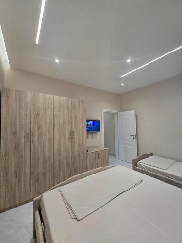 a bedroom with a bed and a tv on the wall at Kejdi Golem Central Apartment in Golem