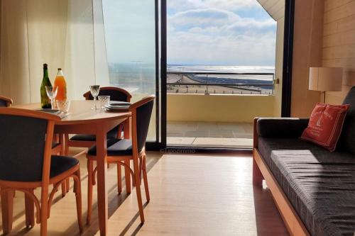 une salle à manger avec une table et un canapé dans l'établissement Tipoz'immo-Le Grand Grand 209 -view and direct access to the sea-pets accep, à Pouldreuzic