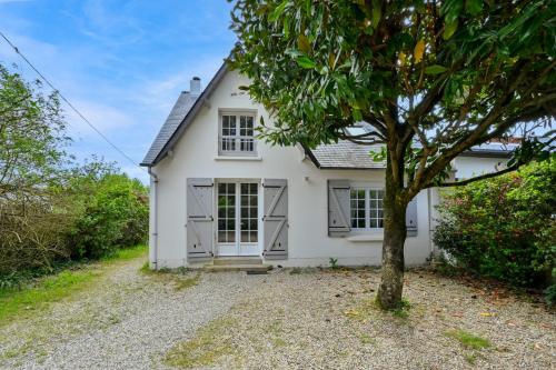 une maison blanche avec un arbre devant dans l'établissement Bois Joli - Pornichet - 7mn à pied plage, à Pornichet