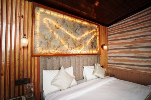a bedroom with a bed with a painting on the wall at Harmony Heights in Mukteswar