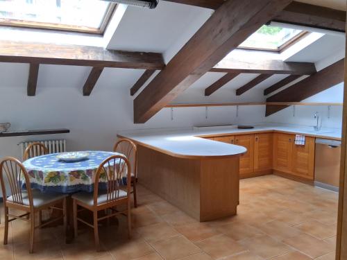 a kitchen with wooden ceilings and a table and chairs at Hotel Ristorante Vapore in Faggeto Lario 