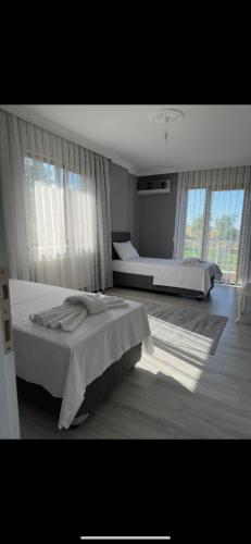 a bedroom with two beds and a large window at Denizin ve doğanın birleştiği yerde mükemmel bir tatil için mükemmel bir villa 9 yataklı- 4 yatak odalı-3 banyolu-3 klimalı in Akcaabat