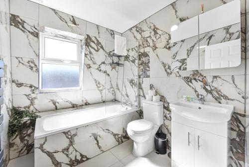 a bathroom with a white toilet and a sink at Cosy 3BR Urban Oasis in London in London