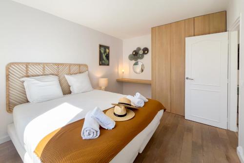 a bedroom with a bed with towels and a hat on it at Magnifique Appartement - M3 in Saint-Tropez