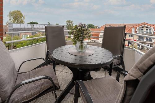 a table with a vase of flowers on a balcony at Haus Meeresgruß Relax in Grömitz