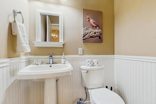 a bathroom with a white toilet and a sink at The Peoria Palms in Peoria