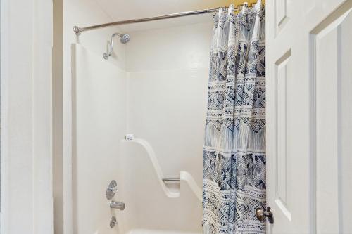 bagno con doccia con tenda blu e bianca di Check's Cozy Condo a Branson