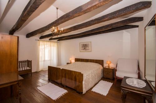 ein Schlafzimmer mit einem Bett, einem Tisch und einem Stuhl in der Unterkunft Holiday Home Troštova Kuća in Pazin