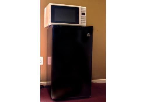 a microwave on top of a black refrigerator at Sherman Inn in Sherman