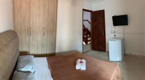 a room with a bed with two slippers on it at Pousada Arraial Beach in Arraial do Cabo