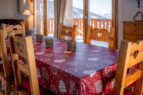 - une table à manger avec une nappe et des chaises violettes dans l'établissement Le Cocon Detached chalet (6p). 3 bedrooms and 2 bathrooms, à Peisey-Nancroix