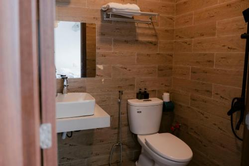 a bathroom with a toilet and a sink at Michelia Valley Hotel in Da Lat
