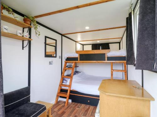 a small room with bunk beds and a desk at Bluebelle Cow Shed 5 in Woodbridge