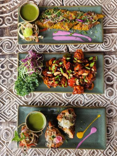 three plates of food on a table with food at The Foresta Resort ,Mulshi in Paud