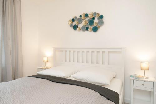 a bedroom with a white bed with two tables and two lamps at Ferienwohnung Jankar in Timmendorfer Strand