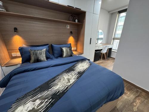 a bedroom with a large blue bed with a wooden headboard at The Centaurus One, Two & Studio Apartments EasyStay in Islamabad