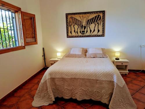 Un dormitorio con una cama y un cuadro en la pared. en Casa Rural en Ohanes, 1 dormitorio - El Cortijo Escondido, La Rosa, en Ohanes