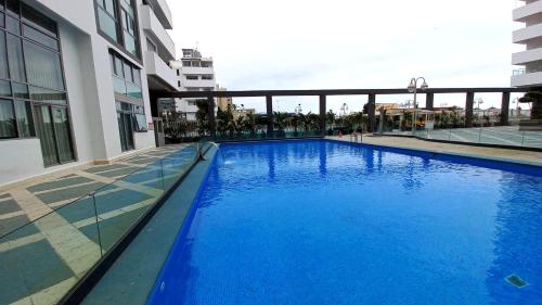 a large blue swimming pool next to a building at Tanger City 3 in Tangier