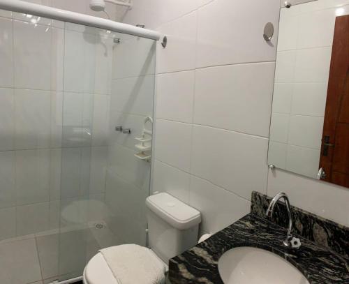 a bathroom with a toilet and a glass shower at Pousada Arraial Beach in Arraial do Cabo