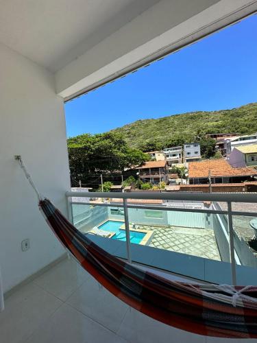 a hammock on a balcony overlooking a swimming pool at Pousada Arraial Beach in Arraial do Cabo