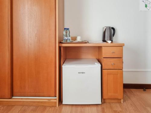 a small white refrigerator sitting under a table at Dolce Vianna - City Centre Rooms in Viana do Castelo