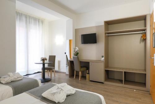 a hotel room with two beds and a desk at Hotel Molino Rosso in Imola