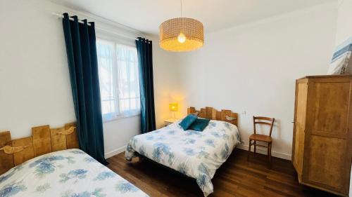 une chambre avec un lit, une chaise et une fenêtre dans l'établissement Les Alouettes centre ville et mer, à Saint-Jean-de-Monts