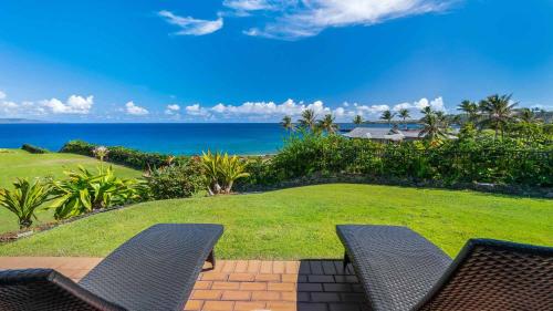 a patio with two chairs and a view of the ocean at Kapalua Bay Villa 18G2 in Kapalua