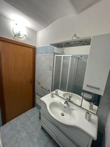 a bathroom with a white sink and a mirror at Affaccio sul Mare in Tropea