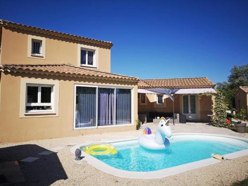 une piscine avec un cygne gonflable en face d'une maison dans l'établissement LS1-370 - campagno, à Paradou