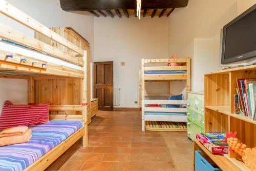 a room with two bunk beds and a tv at Casale Bianca Luce in Santa Luce
