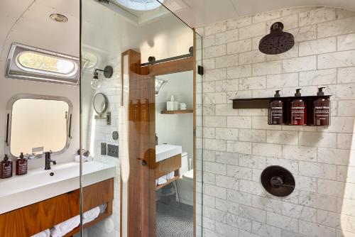 a bathroom with a shower and a sink and a mirror at AutoCamp Sequoia in Three Rivers